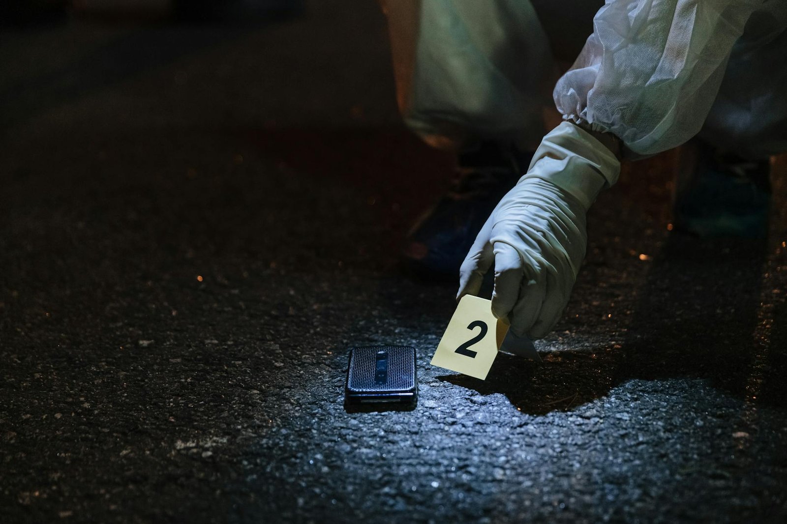 forensics investigator marking an item on the street