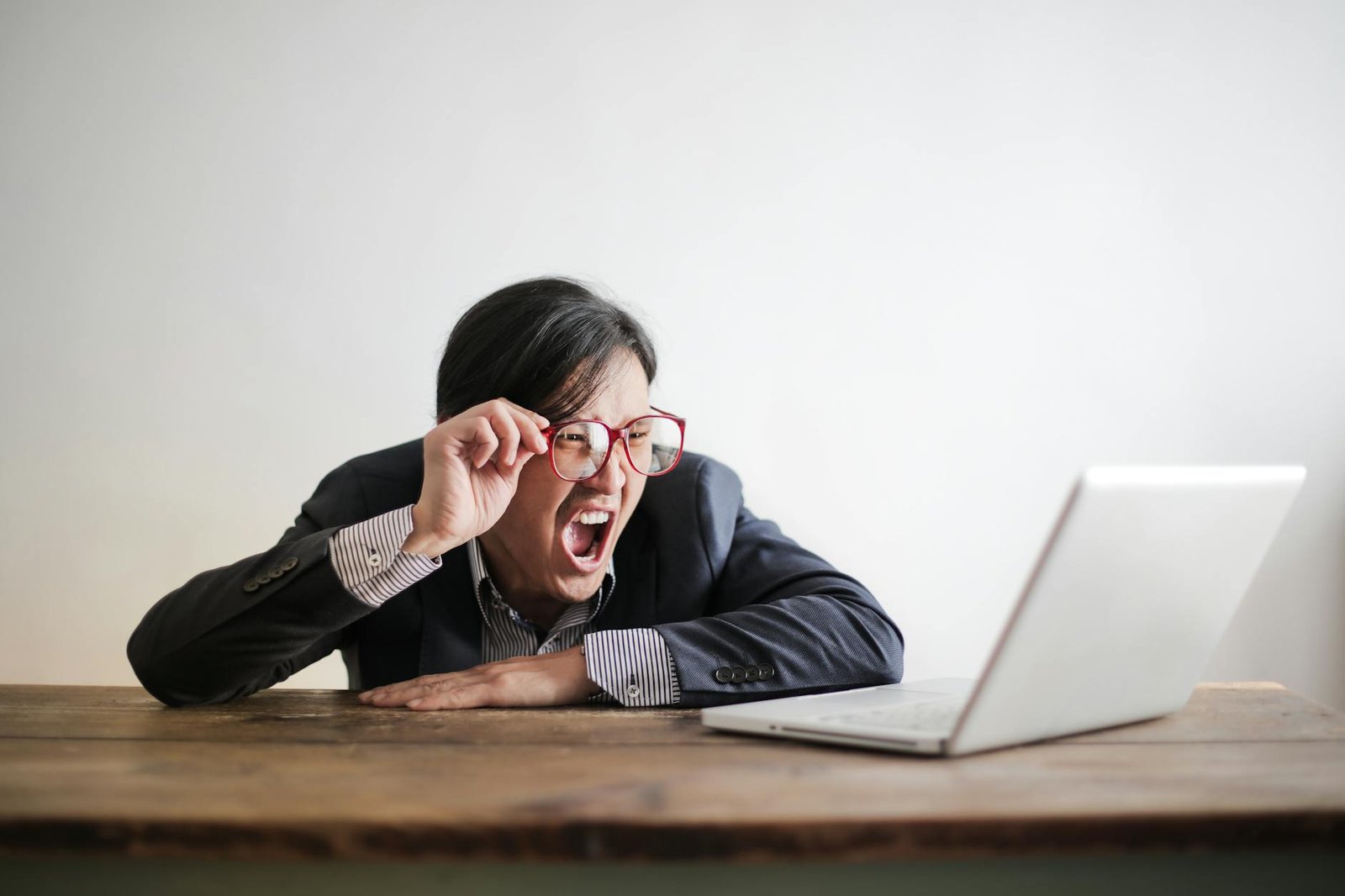 yelling formal man watching news on laptop