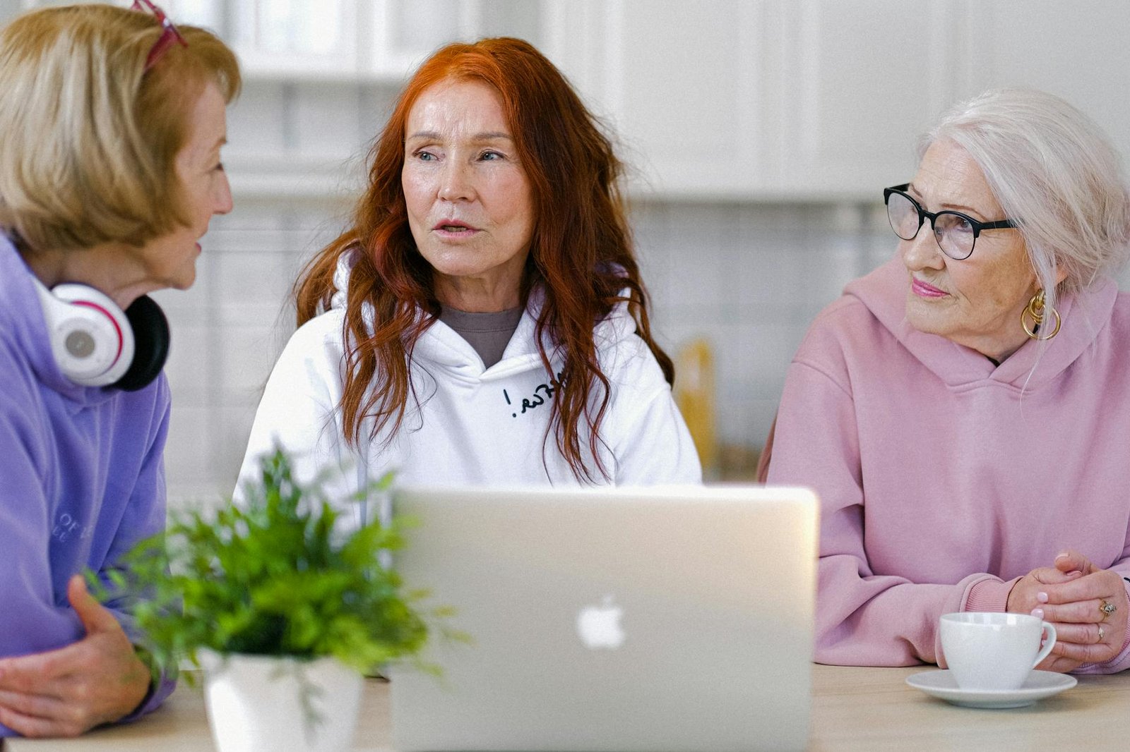 pensive elderly women in stylish clothes speaking in light room