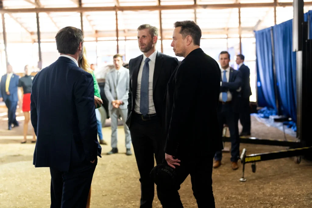 Mr. Musk, right, backstage with Eric Trump, center, and Senator JD Vance during Mr. Trump’s rally in Butler.Credit...Doug Mills/The New York Times