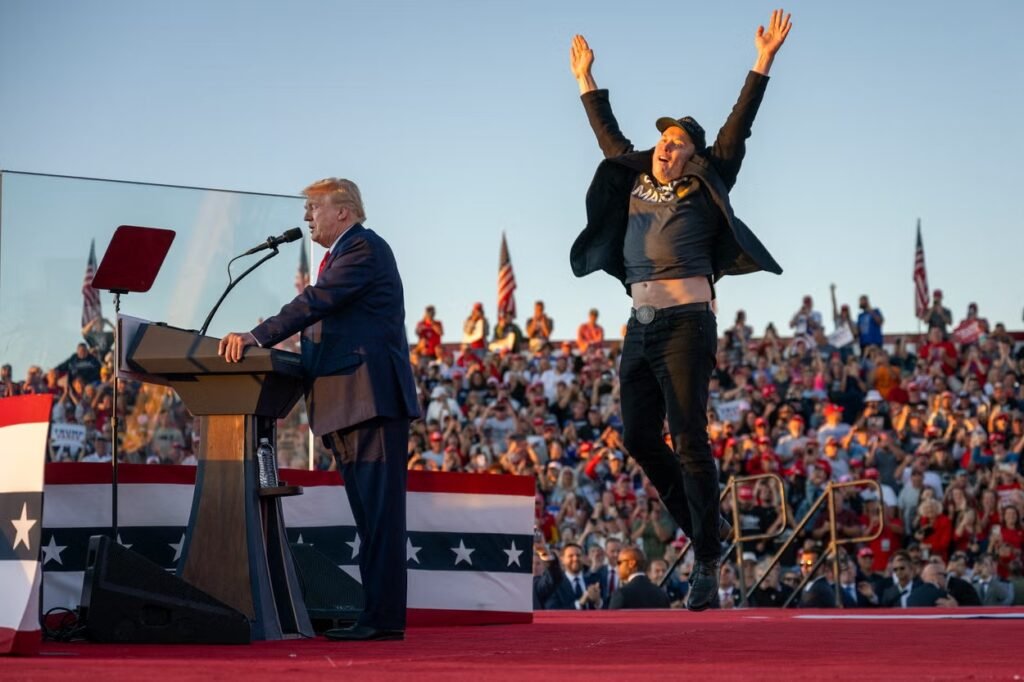 Tesla CEO Elon Musk (R) jumps on stage as he joins former US President and Republican presidential candidate Donald Trump during a campaign rally at site of his first assassination attempt in Butler, Pennsylvania (AFP via Getty Images)